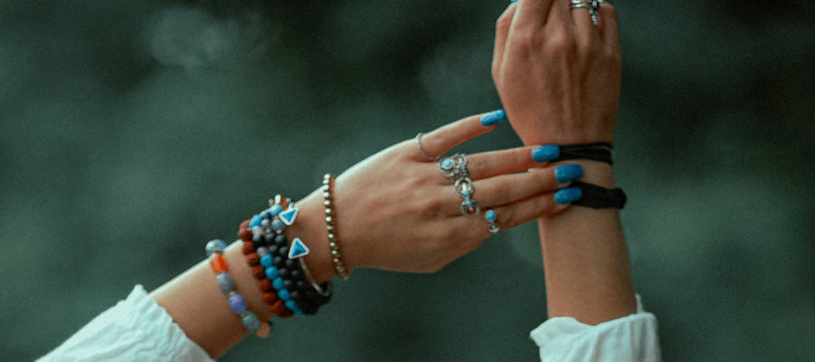 woman's wrists with several bracelets